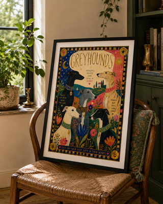 Framed artwork of greyhounds on a chair in a home setting