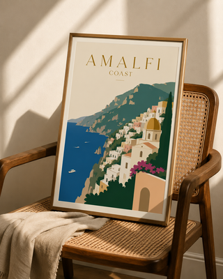 Framed poster of the Amalfi Coast on a wicker chair.