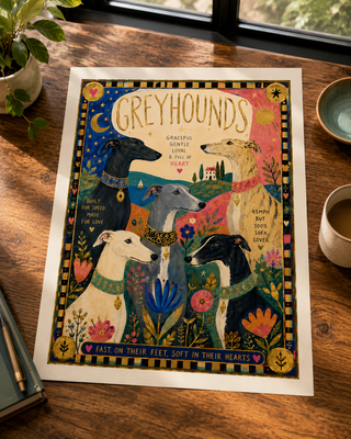 Decorative print of greyhounds on a wooden surface with a cup and plant in the background.